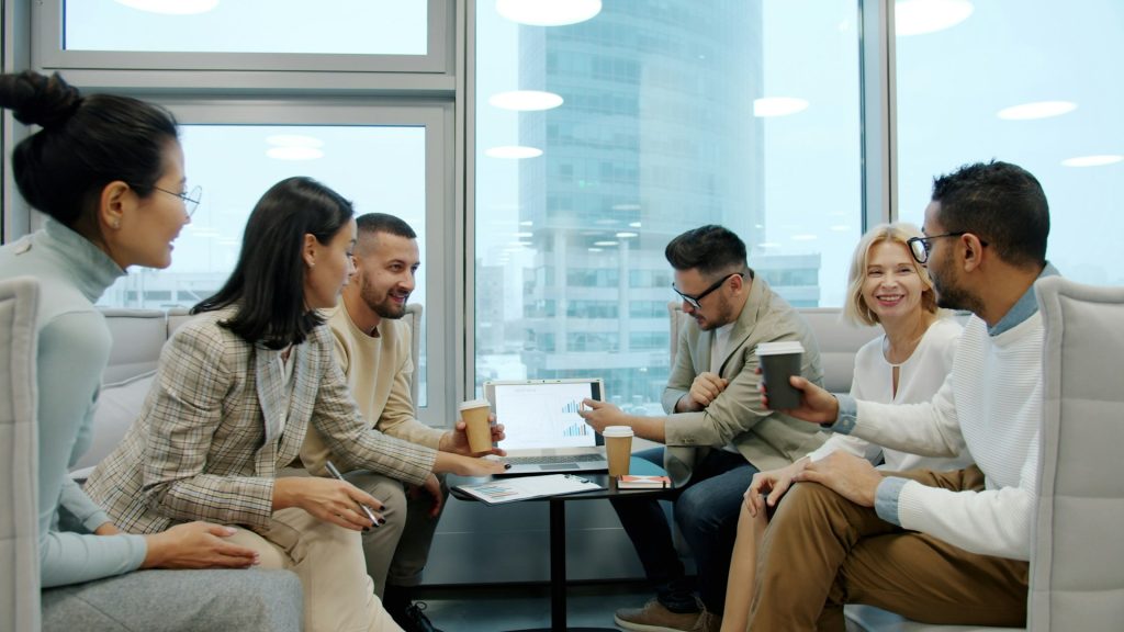 People discussing a chart displayed on a laptop